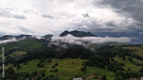 Aerial Hyperlapse Mountain Village With Dramatic Clouds and Fog Over Rocky Peaks