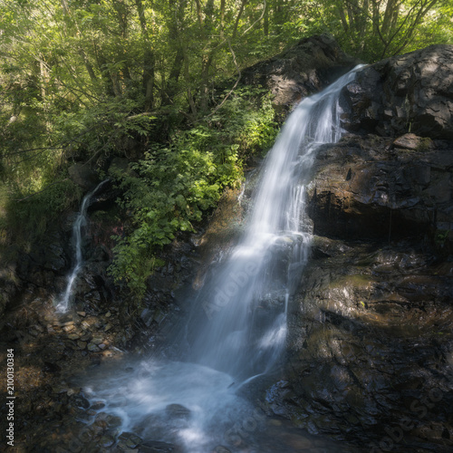 Waterfall Cascades Amidst Lush Greenery in Llivia, Catalonia