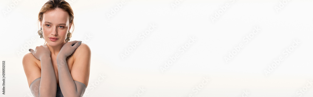 Fototapeta premium Beautiful young woman embodies glamour with glowing makeup in a studio setting