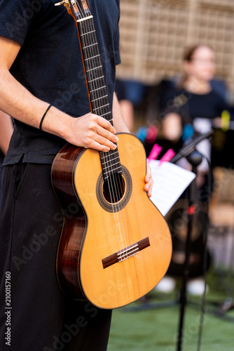 Musician holding classical guitar ready for performance or practice session