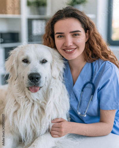 Smiling Veterinarian with Golden Retriever in Clinic