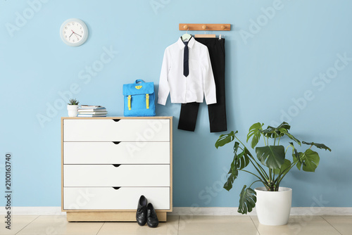 Quadro su tela School uniform with backpack and shoes ready for a new academic year against a b