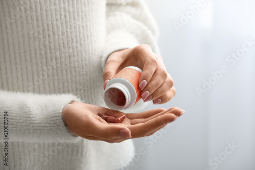 Young woman taking vitamin ...
