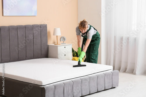 Female janitor cleaning mat...