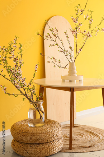 Vases with blooming branche...