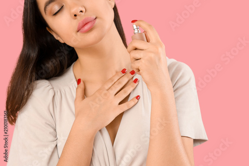 Young woman applying perfum...
