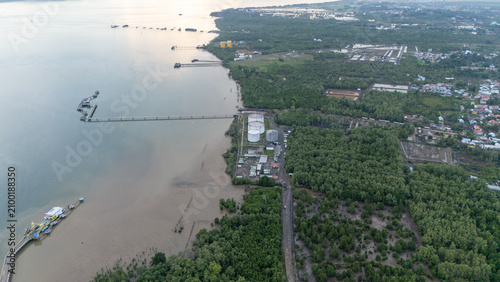 A ferry is docked at the port, while a view of the town of Batulicin and the surrounding sea and river areas can be seen from above