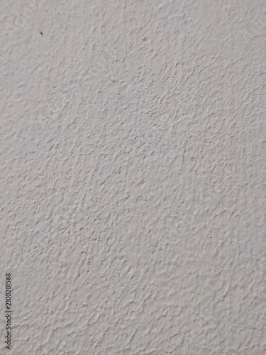 Rough light gray painted wall texture with uneven bumps and ridges