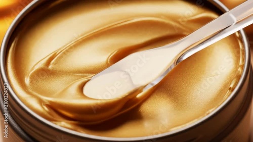 Smooth Golden Peanut Butter Close-Up in Jar with Spoon, Perfect for Culinary Use and Homemade Delights