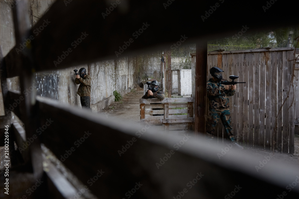 Fototapeta premium Hidden view of soldiers aiming at a target on a training field, leveling their weapons