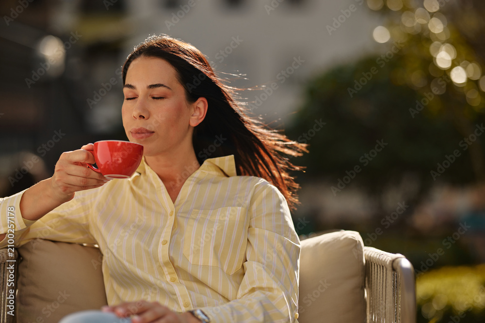 Obraz premium Woman enjoying morning coffee moment in sunlight