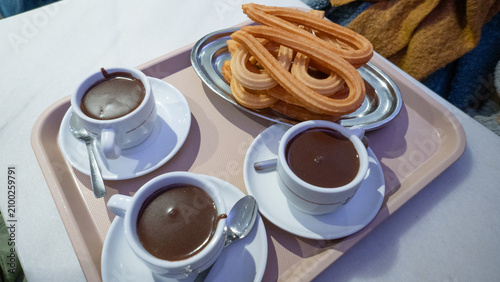 Churros and hot chocolate served on a tray