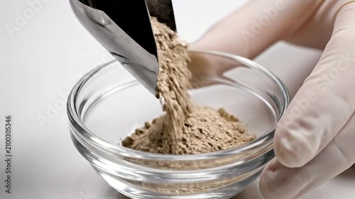 Laboratory Precision: Scientist in Gloves Pours Fine Powder from Stainless Steel Scoop into Glass Dish for Pharmaceutical Research