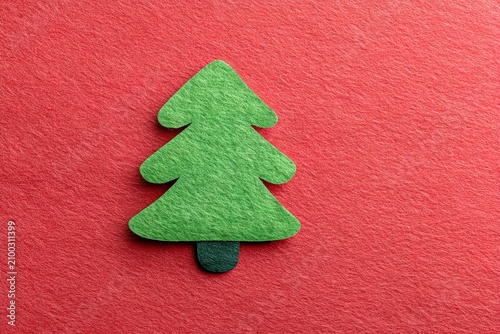 Green felt Christmas tree on red background. Minimalist holiday decor with copy space.