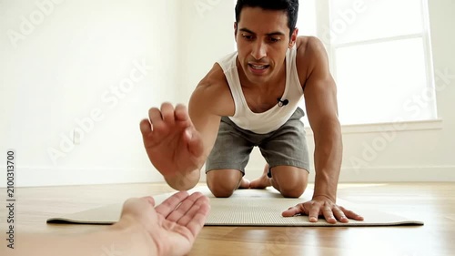 Young Man Reaching Towards Outstretched Hand in Motivational Indoor Fitness Challenge Conveying Determination and Positive Energy