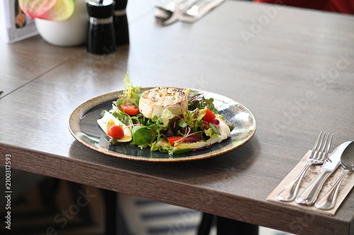 Konstfotografi Grilled cheese served with fresh vegetables on a rustic wooden table in a restau
