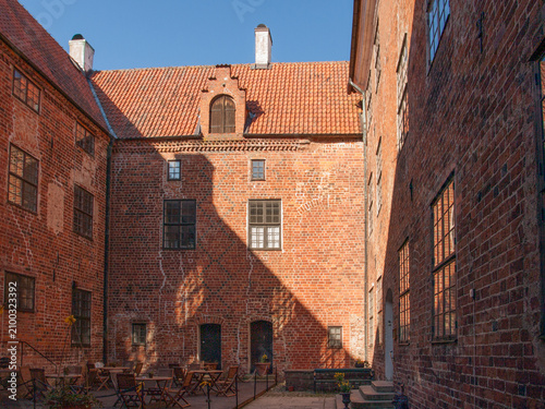 Historic brick courtyard with cafe tables and gable