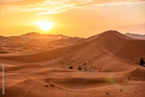 Golden sunrise above rolling sand dunes in Sahara Desert near Merzouga, Morocco