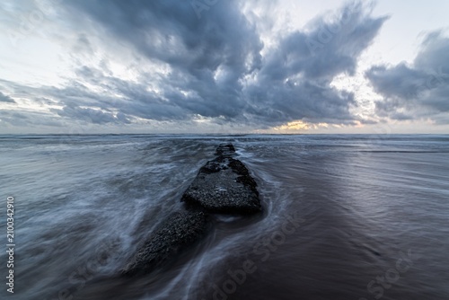 Rain and clouds gather over the sea and rocks at Walney Island on the Cumbrian Coast in the United Kingdom