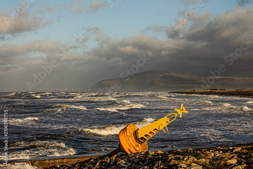 Washed-up buoy on the Cumbrian coast with Black Combe in the background on a stormy day