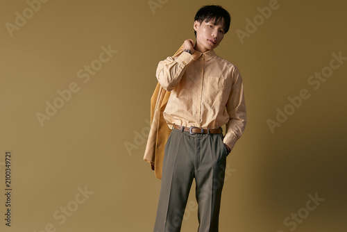 Obraz na plátne Stylish young man flaunts fashion in a chic shirt and pants, posing with flair