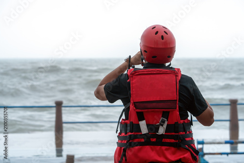 Bild auf Leinwand Rescue Worker Facing Rough Sea While Wearing Safety Gear