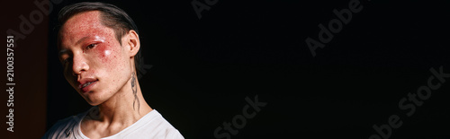 Photos Confident young man in trendy attire strikes a pose against a dark backdrop, exuding charisma