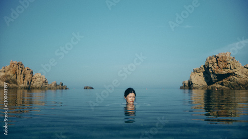 portrait of woman in the sea at sunrise in Sardinia