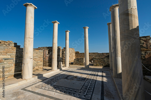 Exploring the House of Dionysos at the Delos archaeological site in the Cyclades region of Greece under clear blue skies