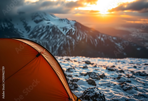Orange tent in a snowy moun...