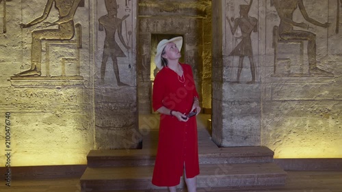 Woman in a red dress exploring the temple in Abu Simbel, Egypt.