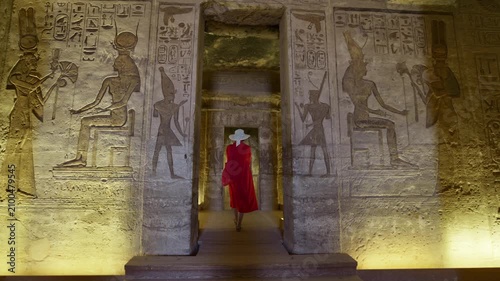 Woman in a red dress exploring the temple in Abu Simbel, Egypt.