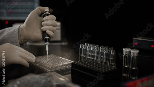 Scientist pipetting samples in genetics laboratory