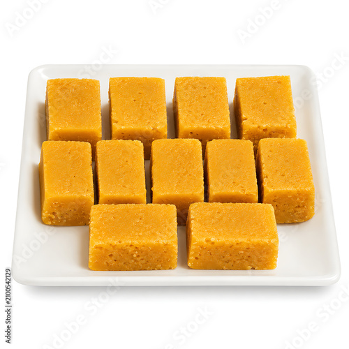 Mysore pak, rich golden gram flour fudge cut into rectangular pieces, isolated on a pure white background.