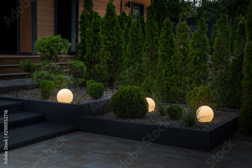 yard design patio, green thuja, evening lighting with balls