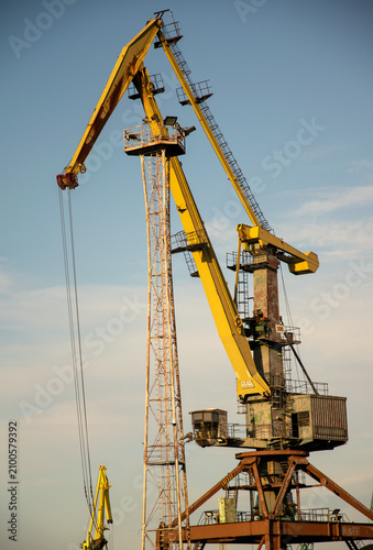 Large yellow gantry harbor crane against a blue sky in the port of Szczecin, Poland.