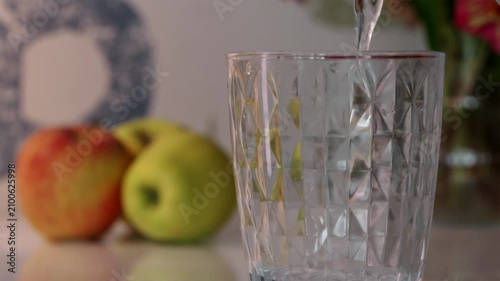 Slow motion of fresh morning water pouring into glass after waking up