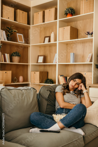 Принти на полотні Young woman feeling bored on sofa watching tv at home