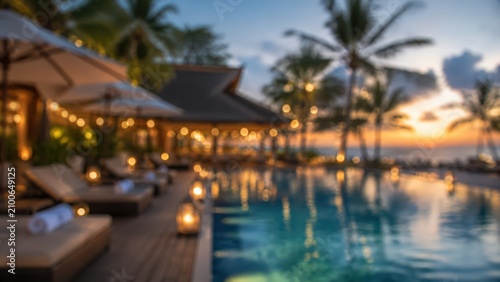 Luxury resort swimming pool blurred sunset background tropical vacation holiday travel bokeh lights evening ambiance palm trees paradise hotel beach