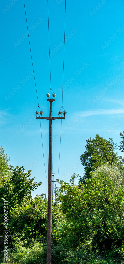 Obraz premium Wooden utility pole with overhead power lines in rural northern Italy