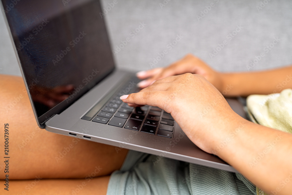 Fototapeta premium Person's hands typing on laptop keyboard