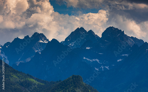 Sunlit green mountain valley with meadow, forested slopes in Zakopane Tatras mountains