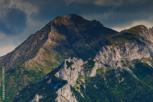 Sunlit green mountain valley with meadow, forested slopes in Zakopane Tatras mountains