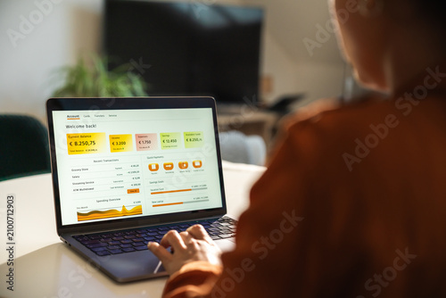 Woman using online banking services on laptop at home
