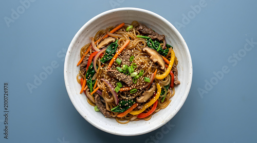 Korean japchae with glossy sweet potato glass noodles stir-fried with carrots, spinach, onions, mushrooms, bell peppers, and marinated beef.