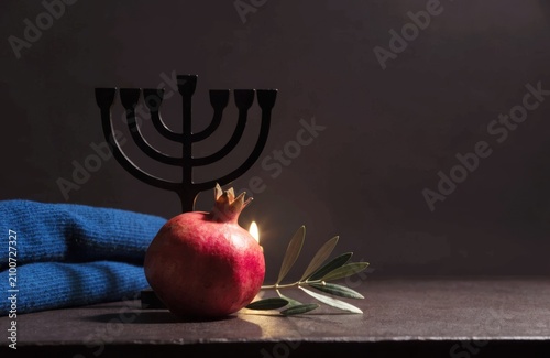 Elegant Jewish faith and heritage still life with pomegranate and menorah