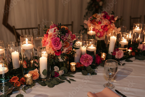 Elegant wedding reception table setting with glowing candles and floral centerpiece