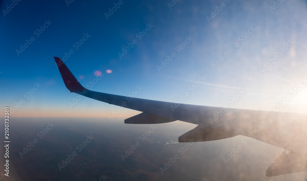 Fototapeta premium View on sunset and airplane wing from the inside