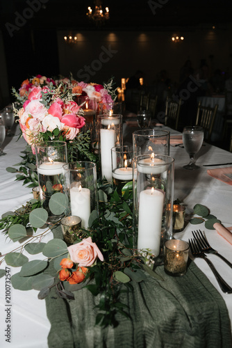 Elegant wedding reception table setting with glowing candles and floral centerpiece