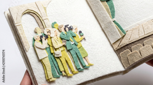 Group of people taking photos in a felt art book display  